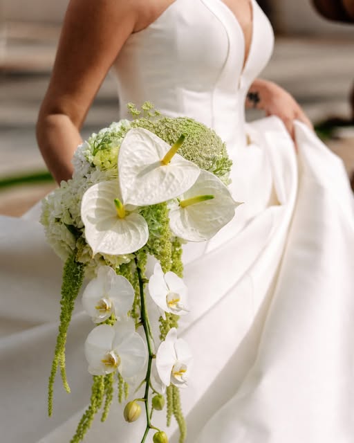 Bride smiling in a floral lace gown